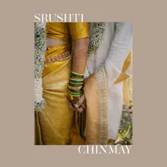 A close-up detail shot of a couple holding hands, showcasing the bride's colorful bangles and the groom's traditional attire. It's a simple yet powerful symbol of their union.