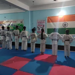 Students standing at attention, facing the Indian flag. Discipline and respect are the first things taught at my academy.