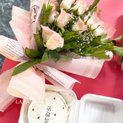 A lovely combo of a simple bento cake with a date and tiny hearts, paired with a beautiful bouquet of pink roses. It's the perfect romantic gift.