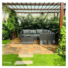 This pergola creates a comfortable and shaded outdoor room, perfect for lounging. The structure is covered with a translucent roof and enveloped by climbing plants, blending architecture with nature.