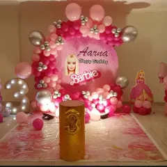 A vibrant Barbie-themed party for a 3rd birthday. This decoration features a custom circular backdrop with the birthday girl's name, multiple shades of pink balloons, Barbie cutouts, and a large foil "3" balloon.