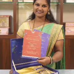 Here is one of my team members showcasing a beautiful peacock-themed invitation set. The vibrant colors of the inserts contrast beautifully with the royal blue box, which is designed to hold both the cards and traditional goodies.
