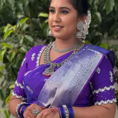 My first bride to wear silver jewellery for her reception. Dr. Indhu looks stunning in a purple Kanjeevaram saree, with her makeup tailored to complement the unique choice of oxidized silver jewellery.