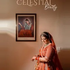 A moment of quiet elegance. The bride, in her beautiful red lehenga, adjusts her bangles, with a classic painting in the background adding to the artistic feel.