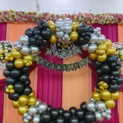 I design elegant decorations for important life milestones like retirement. This party backdrop features a full circle of black, gold, and silver balloons with a "Happy Retirement" banner. This classic color combination provides a festive yet sophisticated look for the occasion.