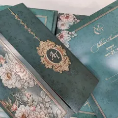 This is a full view of the emerald green floral invitation set. You can see how the custom monogram, the detailed inserts, and the outer envelope all work together to create a cohesive and luxurious suite.
