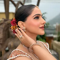 A side view of a sleek bun with a pop of color from fresh flowers. This shows how we can customize a classic hairstyle to match your outfit and personality.