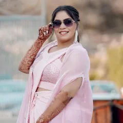 A close-up of the bride, showing off her modern Haldi look with sunglasses and intricate mehendi.