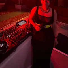 Ready to play at a formal event, standing by my Pioneer mixer. The red ambient lighting set a warm and energetic mood for the evening.