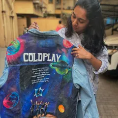 Holding up the finished "A Sky Full of Stars" themed jacket. You can see the scale of the artwork covering the entire back panel of the light-wash denim, ready to be worn to the concert.