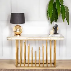 The Golden Spectra Console Table features a unique base of staggered vertical pipes, creating a sense of rhythm and modern artistry. Paired with a marble top, it's a truly stunning piece of accent furniture.