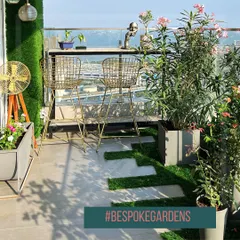 This eclectic balcony features a bar-height table and chairs, perfect for enjoying a morning coffee with a view. We used a mix of flowering plants like Kaner and artificial turf to create a vibrant, low-maintenance space.
