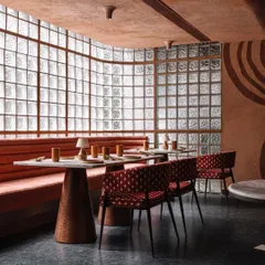 On the upper level of Idylll, a wall of glass blocks allows diffused natural light to fill the space. The design combines a subdued color palette with varied textures to create a prelude for the fine dining experience.