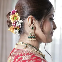 A beautiful bridal bun decorated with a mix of colorful fresh flowers, adding a vibrant touch to the traditional look.