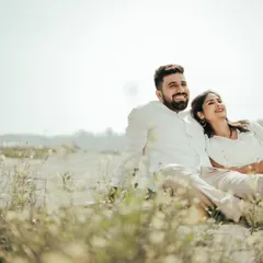 A couple relaxes in a sun-drenched field, showcasing the serene and natural side of our location. It's a perfect spot for casual, light-hearted, and romantic photos.