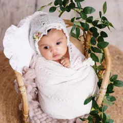 This is why I adore newborn photography. This peaceful baby is swaddled in soft white fabric, nestled in a rustic basket with delicate greenery, creating a pure and natural portrait.