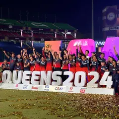 Queens of 2024. The entire RCB squad and support staff celebrating on the podium after the WPL final. A proud moment for everyone involved in this amazing setup.