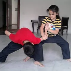 My classes for kids focus on practical self-defense. Here, students are learning how to apply techniques safely to control a situation, building confidence and real-world skills.