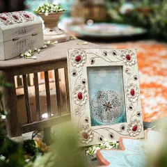 Every detail in this South Indian wedding was a nod to royalty. This close-up shows a hand-carved photo frame and a vintage-style chest, accented with fresh mogra, embodying the regal and timeless theme.