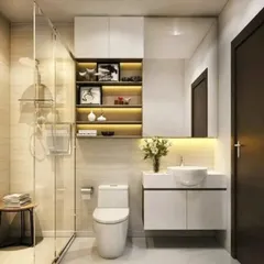 A compact bathroom design that maximizes space with a floating sink, a large mirror, and a glass shower partition. The built-in shelves with lighting add both storage and ambiance.