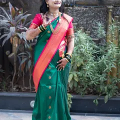 A full-length portrait of a Marathi bride in a traditional green Paithani saree, showcasing her complete bridal look.