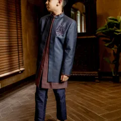 Every detail tells a story of elegance. This layered Indo-western outfit from our Jashn Collection features a deep blue jacket with a subtle, hand-embroidered motif over a contrasting kurta.