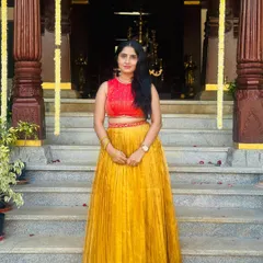 A beautiful Kanchivaram tissue pleated skirt in mustard yellow, paired with a contrasting red hand-embroidered silk crop top. This is a modern way to wear traditional fabrics.