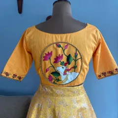 A custom-designed yellow blouse featuring a hand-painted Pichwai art motif on the back. This piece combines traditional Indian art with modern tailoring, a specialty I offer for clients seeking truly unique ethnic wear.