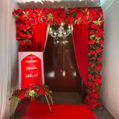 The perfect welcome to a classic Indian wedding. This entrance is framed by a thick arch of red flowers, with red drapes and a red carpet leading guests into the celebration.