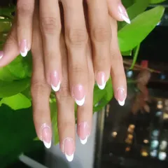 The classic French manicure on long, almond-shaped nail extensions. It's a timeless look that is always in style and perfect for any occasion.
