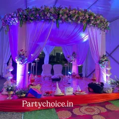 This mandap was designed for a Bengali wedding ceremony. We used purple and white drapes, a dense floral arrangement on top, and traditional elements on the stage to create an intimate and culturally specific setting inside a tent.