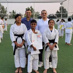 A proud moment as our new black belt student poses with his senseis and fellow black belts after a successful grading.