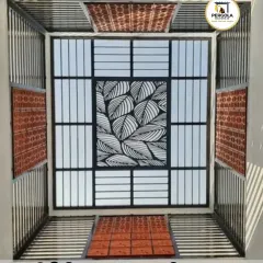 A unique skylight design combining a central laser-cut panel with a leaf motif, surrounded by frosted glass and terracotta jali bricks. This eclectic mix of materials creates a one-of-a-kind architectural feature.