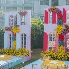 A 'Rang Rang Mein' themed Haldi, celebrating all the colors of life. The decor features multi-colored windows as a backdrop, surrounded by bright, playful floral arrangements.