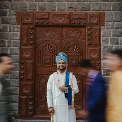 A creative portrait of the groom using motion blur. The groom stands sharp and smiling in the center while the movement of guests rushes past him.