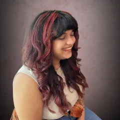 A rock chick shag haircut with red accents for Amrapali. This cut is full of texture and personality.