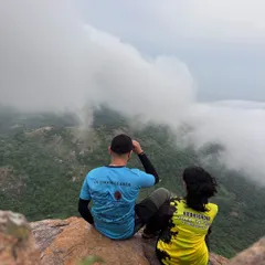 Two of our team members looking out over a valley filled with clouds. We create custom, unforgettable experiences for corporate groups and teams.