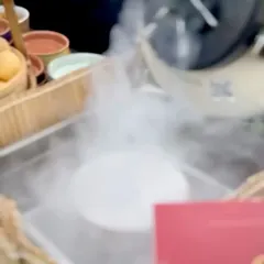 A dramatic cloud of smoke billows from a bowl at our live chaat station. This touch of theatre adds an element of surprise and delight, transforming a simple dish into a memorable experience.