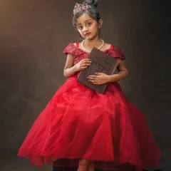 A little princess in a grand red ball gown. This fine art portrait has a classic, painterly feel, turning a childhood photo into a timeless piece of art.