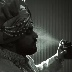 Say hello to the luckiest man in the world. A creative black and white shot of the groom getting ready, with a spray of perfume caught in the light.