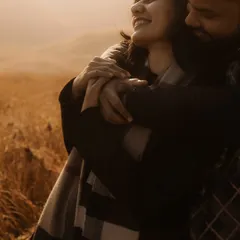 A warm and joyful embrace in a field of gold. The soft, hazy light and the bride's happy expression make this an incredibly heartwarming and candid portrait.