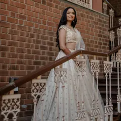A vision in white. This bride's elegant Tarun Tahiliani lehenga looks absolutely stunning against the rustic brick backdrop, creating a timeless and regal bridal portrait.