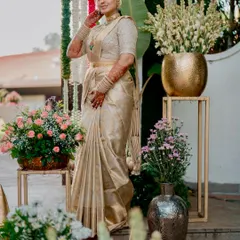 A full-length portrait of a bride in a magnificent golden Kanchipuram saree. The saree's rich texture and the blouse's detailed embroidery create a regal and unforgettable bridal look.