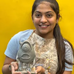 Student Hena with her fantastic sculpture of Mike Wazowski from the movie Monsters, Inc. This project helped her develop skills in creating animated forms, expressions, and textures in clay.