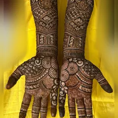 This bridal design is packed with detail, featuring floral mandalas on the palms and varied, intricate bands running up the arms. Every inch is filled with beautiful artistry.