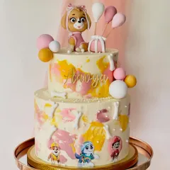 This two-tiered Paw Patrol cake features Skye as the main topper, surrounded by edible images of the whole pup squad. The watercolour buttercream effect and fondant balloons add a playful touch for a special birthday.