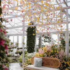 A beautiful shot of the seating area, with a canopy of hanging yellow and pink orchids. The design was meant to feel like being inside a blooming garden.