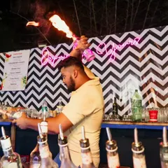 A flair bartender caught in action, expertly handling flaming bottles. This is the kind of entertainment we bring to add excitement and a 'wow' factor to your party.