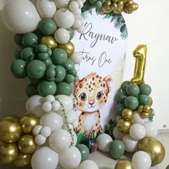 The color palette is key to a beautiful setup. For this jungle-themed first birthday, I used a combination of sage green, white, and chrome gold balloons to complement the personalized "Raynav turns One" backdrop, creating a soft yet festive look.