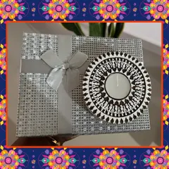 A beautifully wrapped Diwali gift box. This silver package, tied with a ribbon and adorned with a decorative diya, contains a selection of my healthy vegan treats, making it a perfect festive gift.